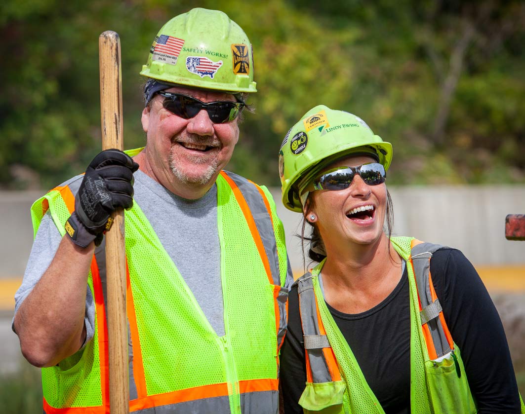 two construction workers smiling and laughing together on job site