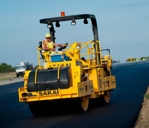 construction working smoothing asphalt with a road roller